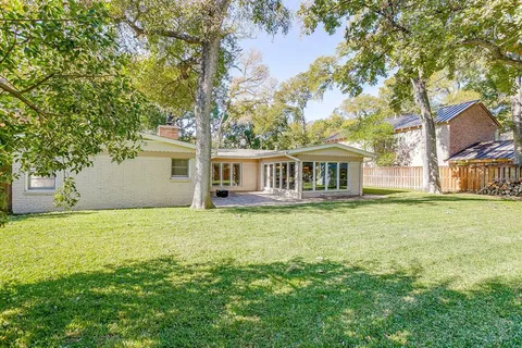a house that has a big yard with large trees