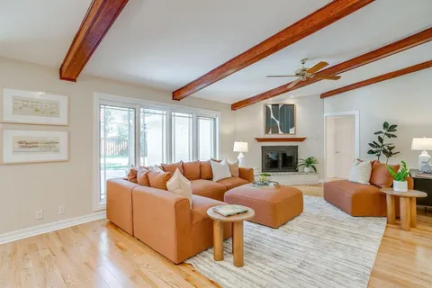 a living room with fireplace furniture and a wooden floor