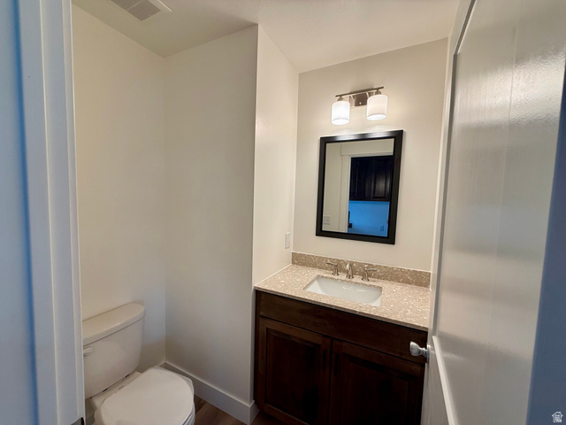 2865 North 3250 W Road Sutherland, UT 84624 - Photo 14 of 28 Bathroom featuring a dark wood vanity with a light speckled countertop, undermount sink, and a framed mirror
