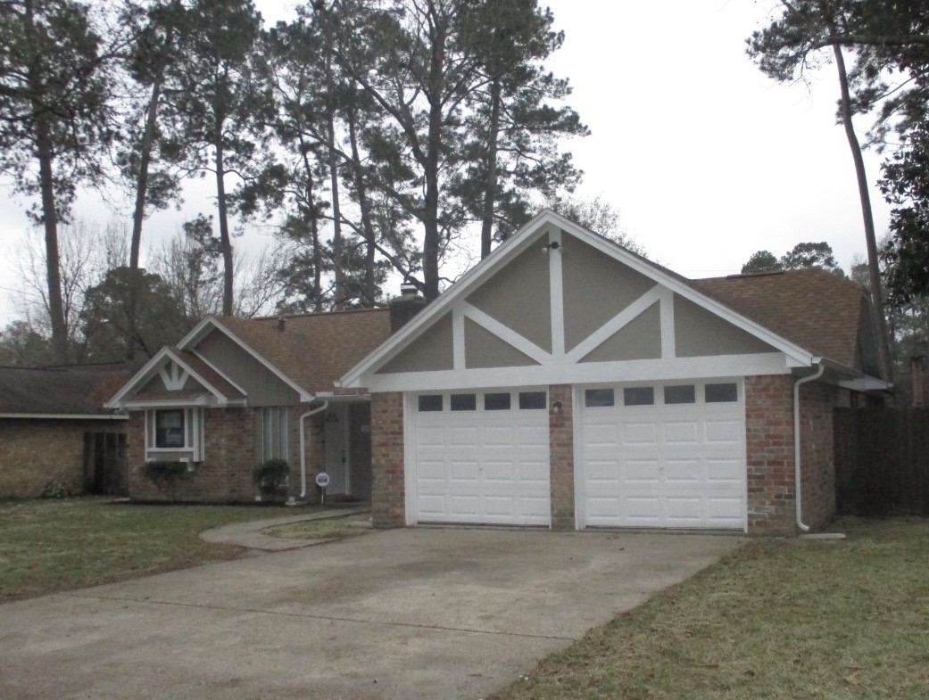 2106 Woodway Drive Woodbranch, TX 77357 - Photo 2 of 17 a front view of a house with a yard and garage