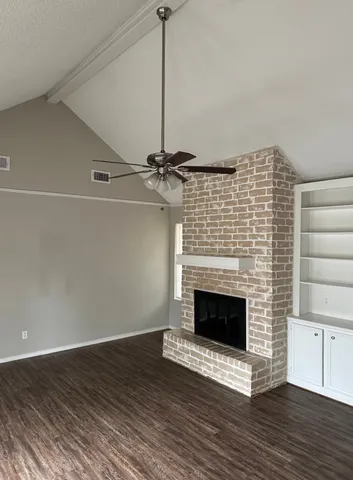 a view of empty room with wooden floor and fireplace