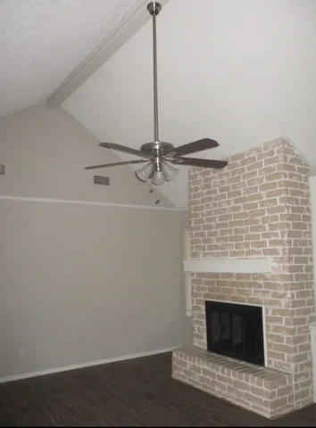 a room with a fireplace and a ceiling fan