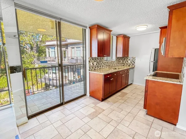 a view of a kitchen with kitchen island granite countertop a large window and a sink