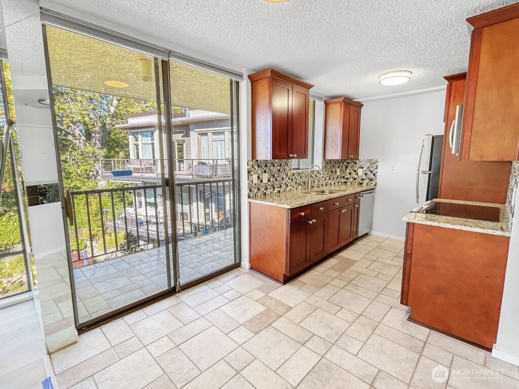 4561 Lake Washington Boulevard Northeast, Unit 303 Kirkland, WA 98033 - Photo 3 of 16 a view of a kitchen with kitchen island granite countertop a large window and a sink
