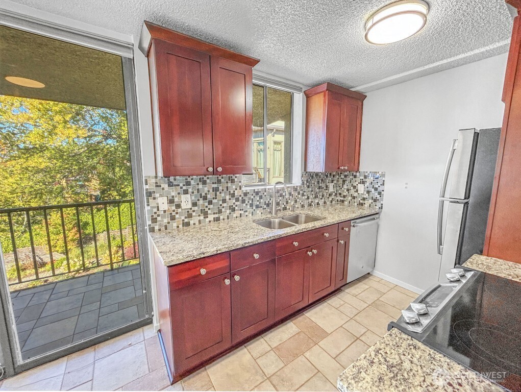 4561 Lake Washington Boulevard Northeast, Unit 303 Kirkland, WA 98033 - Photo 4 of 16 a spacious bathroom with a granite countertop sink and a large mirror