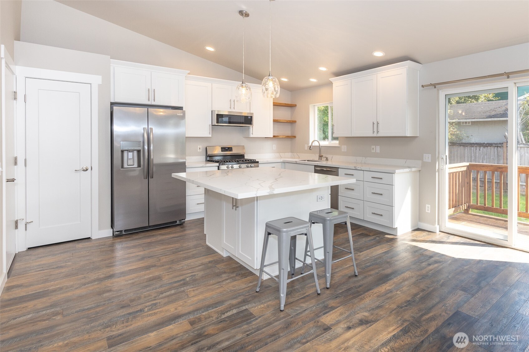 105 May Creek Road Gold Bar, WA 98251 - Photo 22 of 38 a kitchen with stainless steel appliances a refrigerator a sink dishwasher a stove and white cabinets with wooden floor