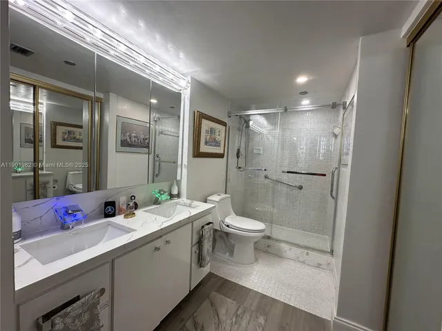a bathroom with a double vanity sink mirror and toilet