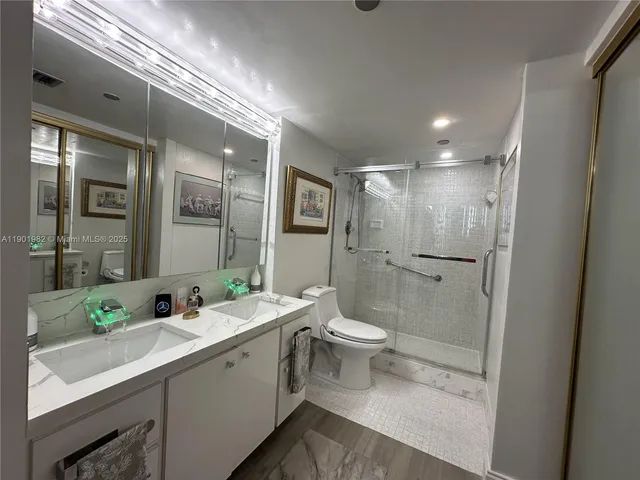 a bathroom with a double vanity sink toilet and shower