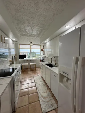 a kitchen with a sink and white cabinets
