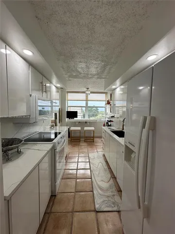 a kitchen with a sink a counter top space stainless steel appliances and cabinets