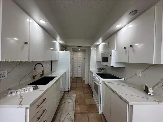 a kitchen with stainless steel appliances granite countertop a sink and a stove top oven