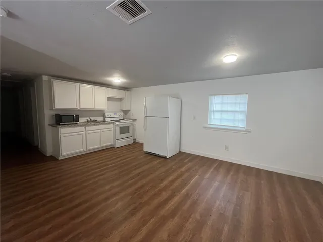 a view of kitchen with wooden floor and electronic appliances