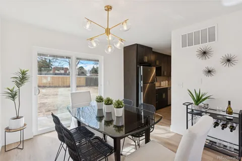 a dining room with furniture potted plants and wooden floor