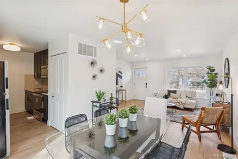 a view of a dining room with furniture a chandelier and wooden floor
