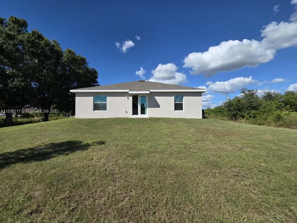 3403 34th Street Southwest, Unit 3403 Lehigh Acres, FL 33976 - Photo 16 of 16 a view of house with yard and trees in the background