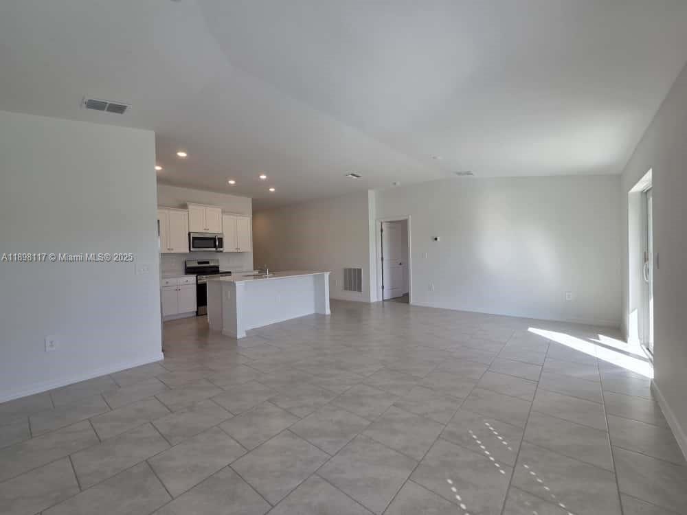 3403 34th Street Southwest, Unit 3403 Lehigh Acres, FL 33976 - Photo 3 of 16 a view of kitchen with kitchen island and stainless steel appliances