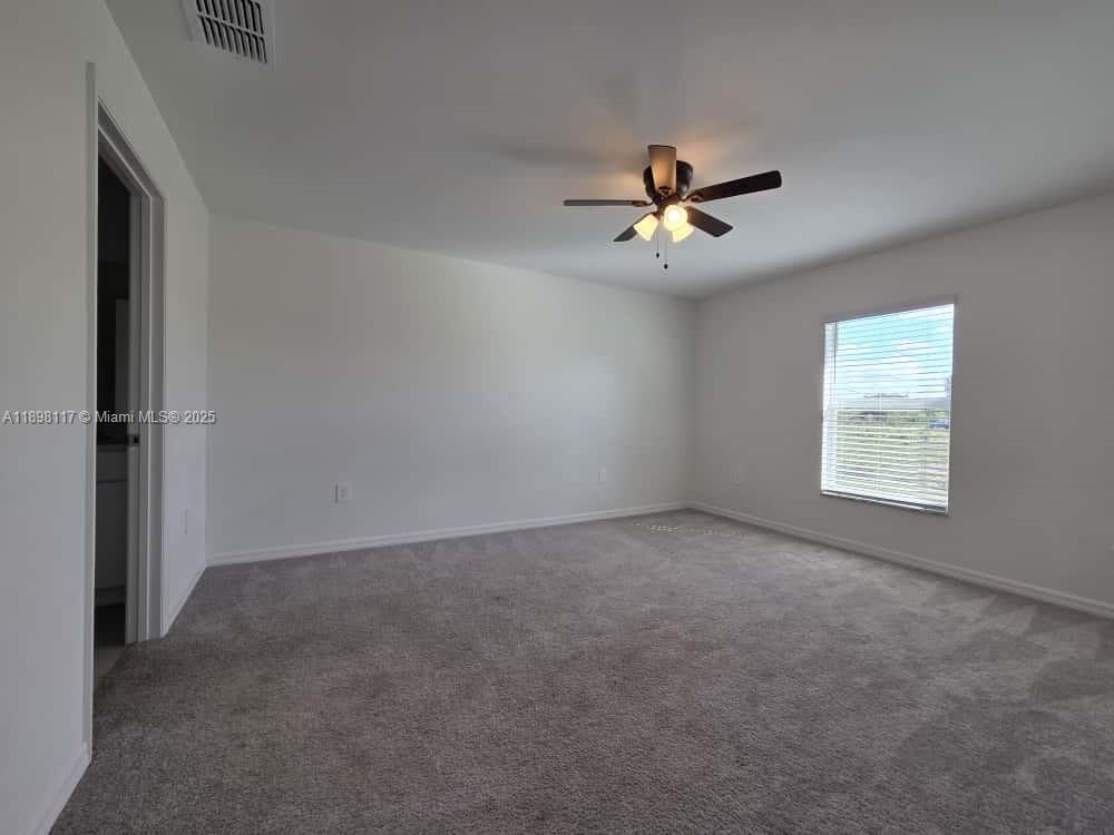 3403 34th Street Southwest, Unit 3403 Lehigh Acres, FL 33976 - Photo 6 of 16 an empty room with windows and ceiling fan