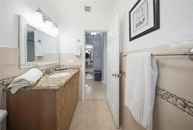 a bathroom with a granite countertop sink a mirror and shower
