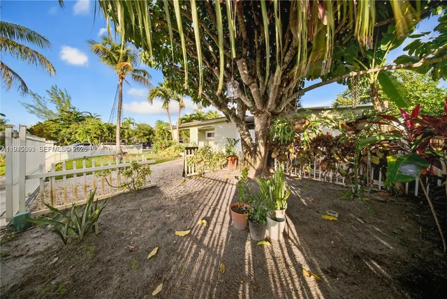 a front view of a house with a yard and potted plants