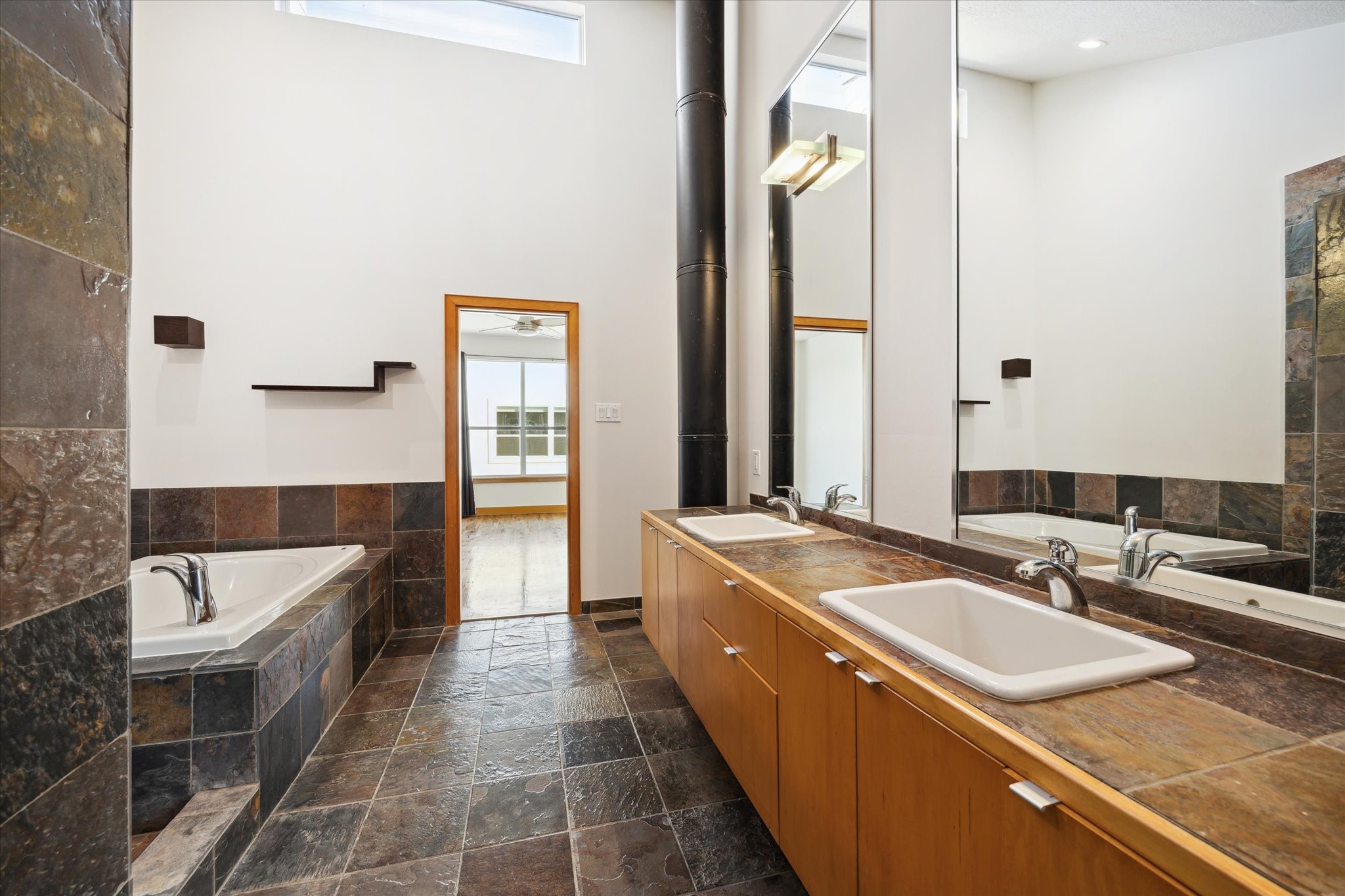 94 Drew Street, Unit C Houston, TX 77006 - Photo 20 of 29 Primary bath features dual vanities, offering ample counter space and a well-appointed layout that blends everyday functionality with a refined, spa-like feel.