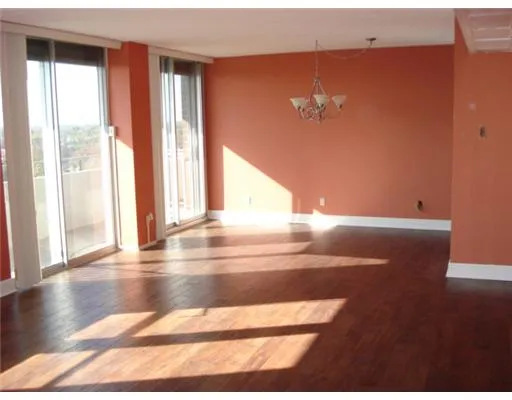 a view of a room with wooden floor and a floor to ceiling window