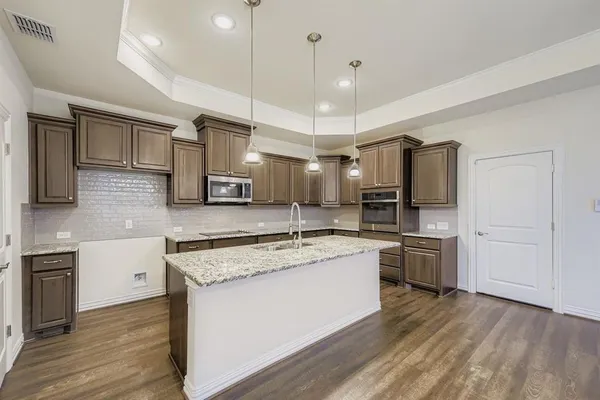 a kitchen with stainless steel appliances granite countertop a sink a stove and refrigerator