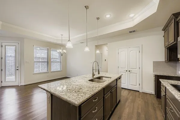 a kitchen with kitchen island a sink stove and wooden floor