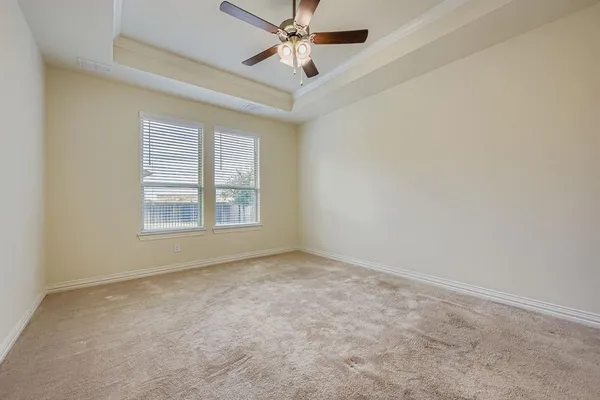 an empty room with windows and ceiling fan