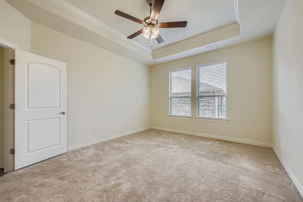 an empty room with windows and fan