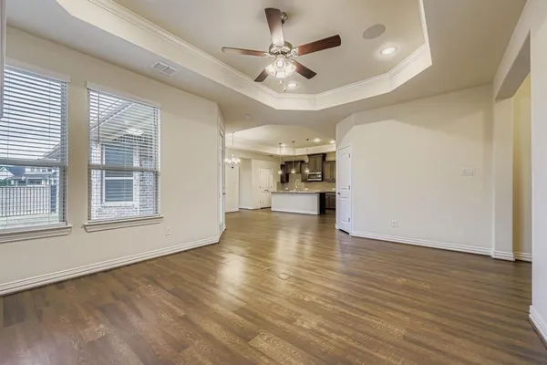a view of empty room with wooden floor and ceiling fan