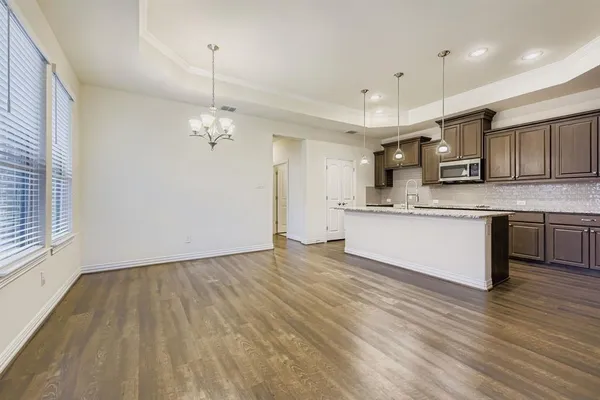 a large kitchen with stainless steel appliances granite countertop a sink a oven a counter space and cabinets