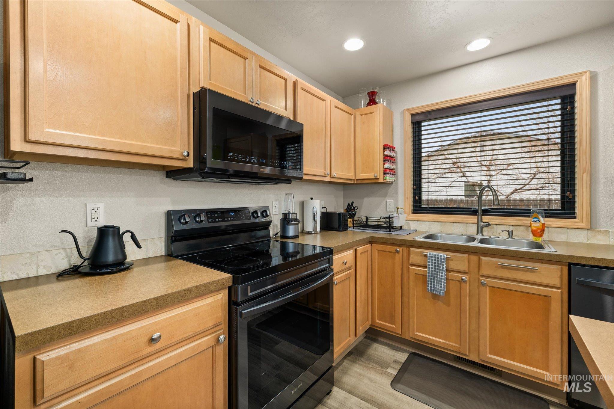 7166 Yellow Fern Road Nampa, ID 83687 - Photo 15 of 35 Kitchen with range with electric cooktop, black dishwasher, light wood-type flooring, recessed lighting, and light wood finish cabinetry