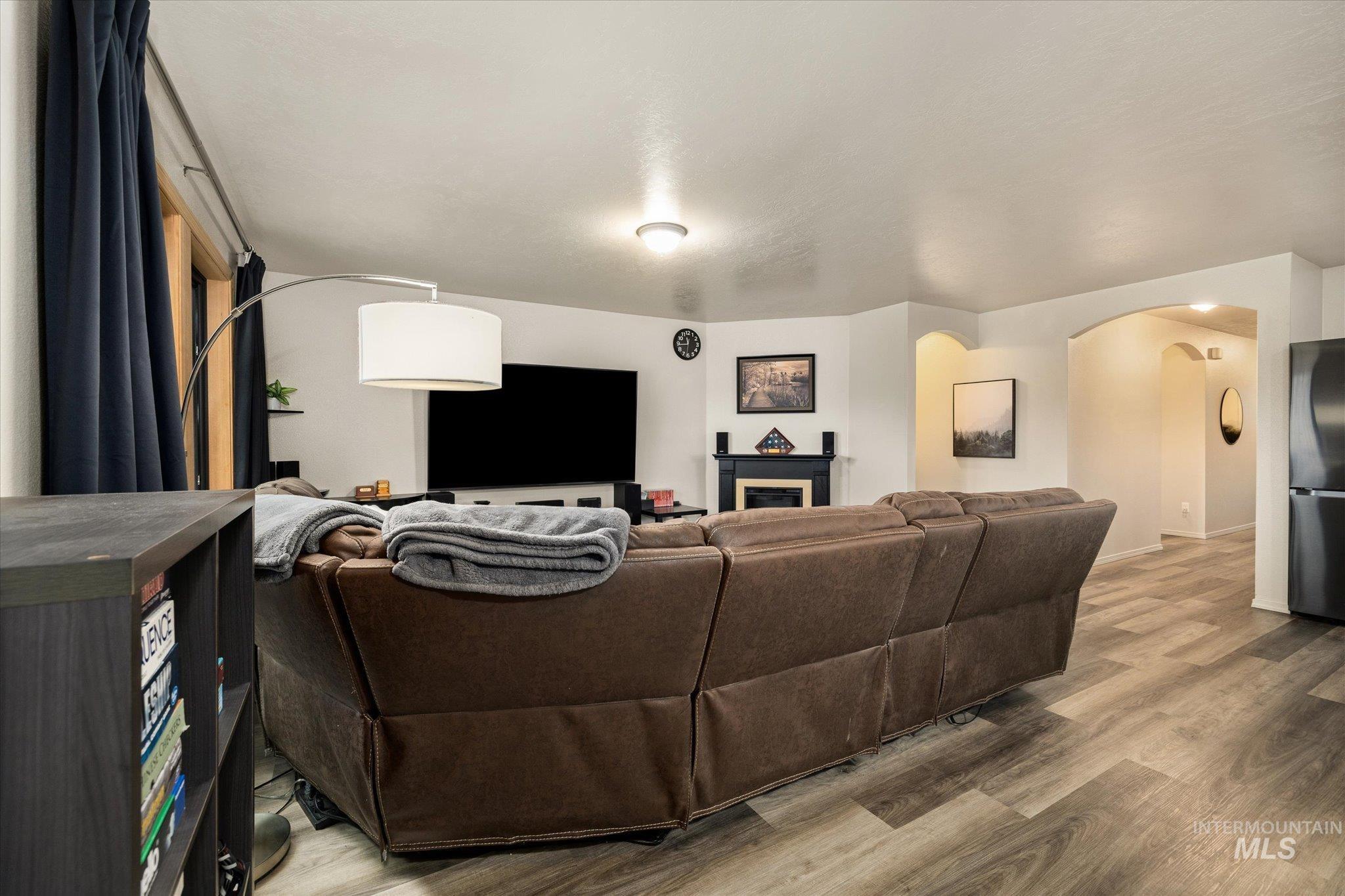 7166 Yellow Fern Road Nampa, ID 83687 - Photo 9 of 35 Living area featuring light wood-style flooring, arched walkways, and a fireplace