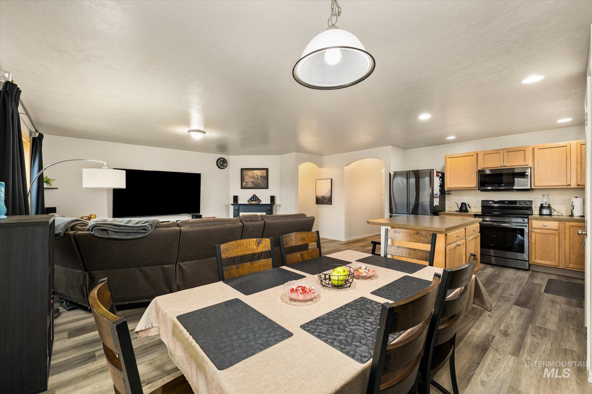 7166 Yellow Fern Road Nampa, ID 83687 - Photo 10 of 35 Dining space featuring arched walkways, light wood finished floors, and recessed lighting