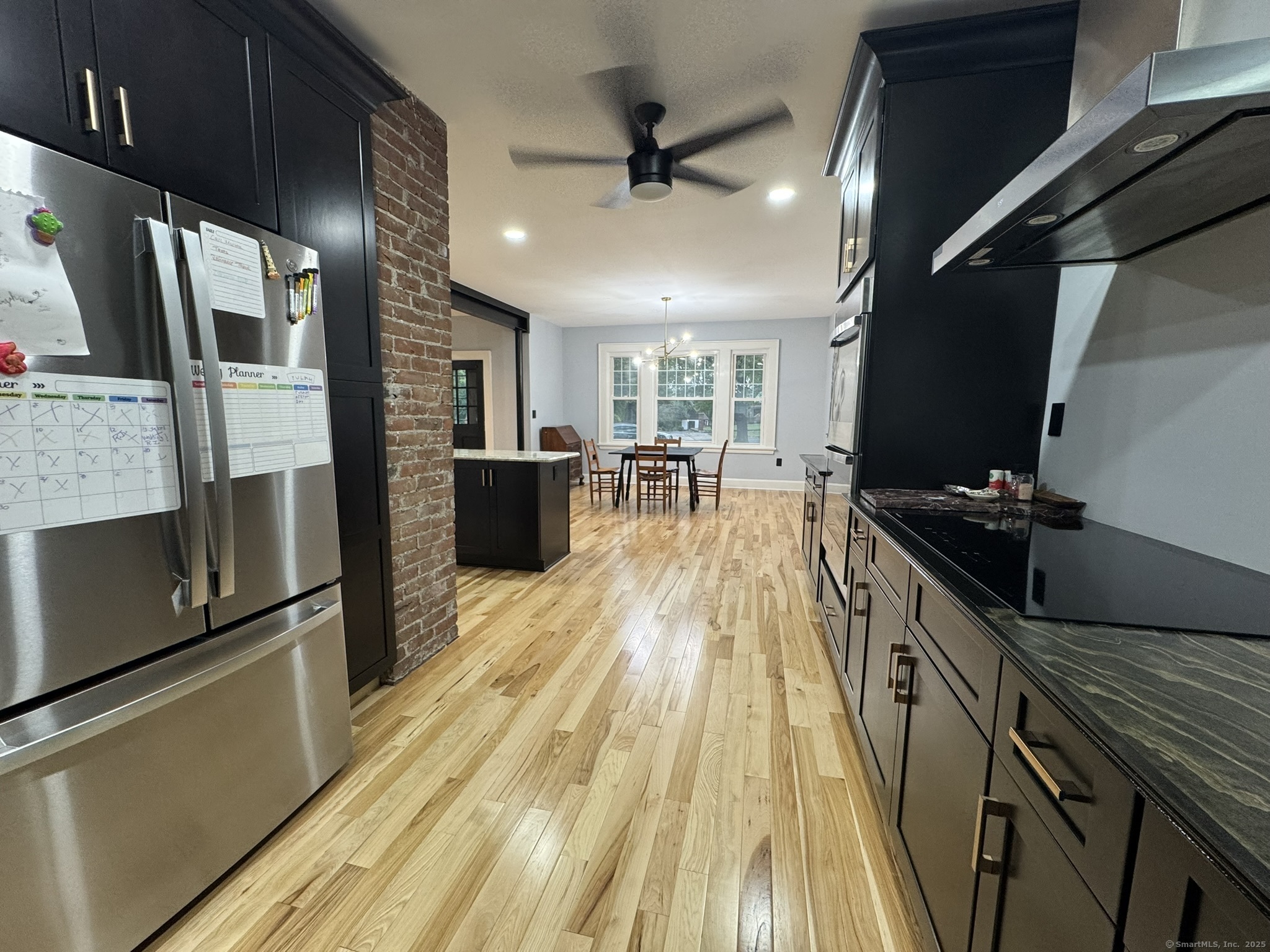 127 Lambert Avenue Meriden, CT 06451 - Photo 8 of 37 a kitchen with stainless steel appliances granite countertop a refrigerator a sink dishwasher a stove and a dining table with wooden floor