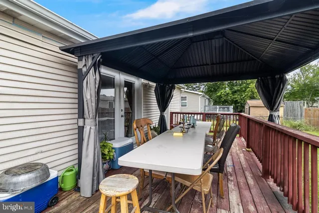 a view of deck with table and chairs under an umbrella
