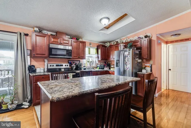 a kitchen with stainless steel appliances granite countertop a stove refrigerator and a wooden cabinets