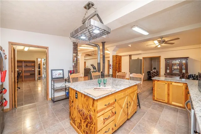 a large kitchen with kitchen island a large counter space a sink appliances and cabinets