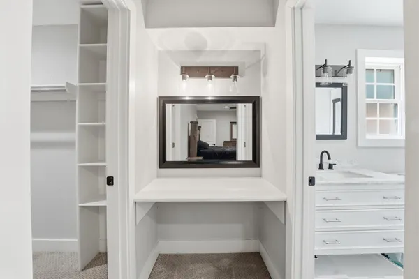 a hallway with a large mirror and cabinets