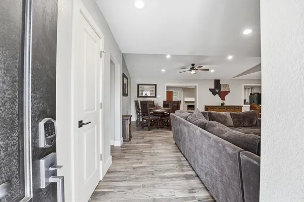 a living room with furniture kitchen view and a chandelier