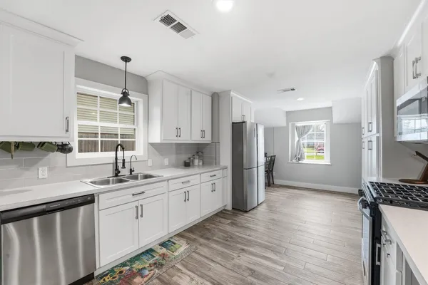 a kitchen with a sink a window and stainless steel appliances