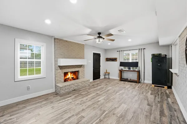 a view of a livingroom with a fireplace window and wooden floor