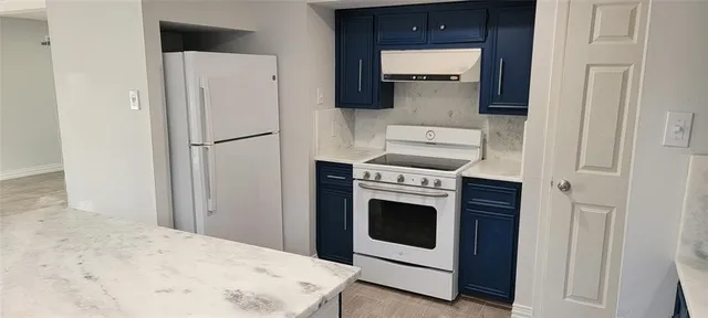a kitchen with a white stove and white cabinets
