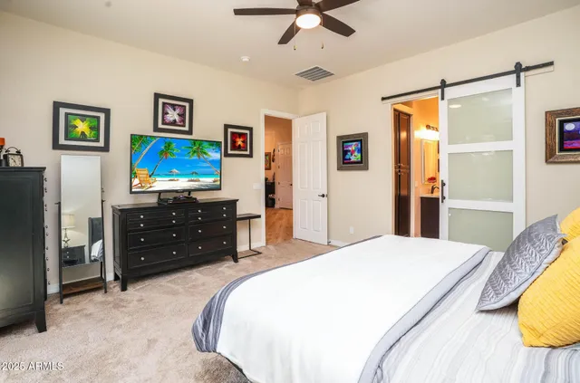 a spacious bedroom with a bed and a tv