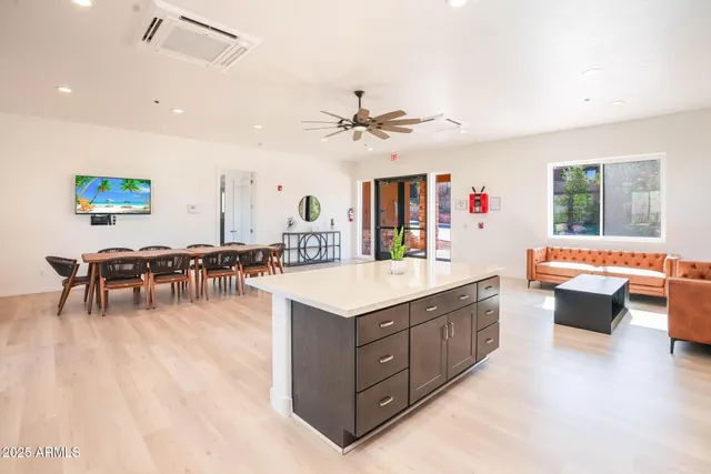 a living room with furniture a dining table and a large window