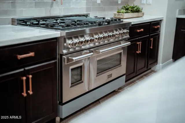a kitchen with stainless steel appliances granite countertop a sink and a stove