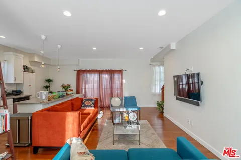 a living room with furniture a couch and wooden floor
