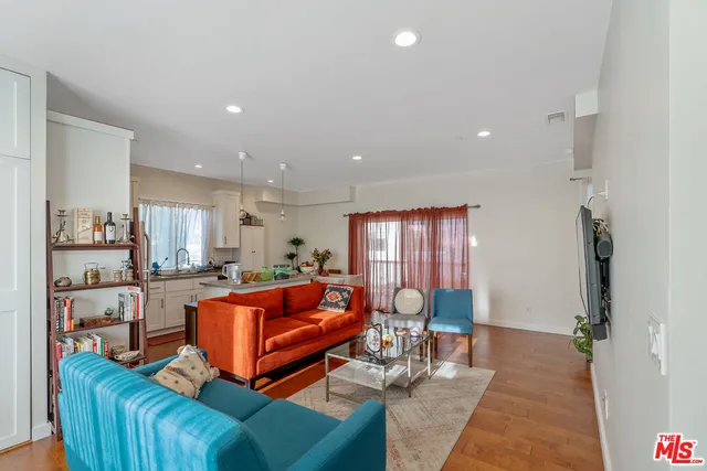 a kitchen with a refrigerator a sink dishwasher a stove and white cabinets with wooden floor