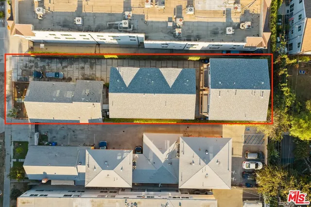 an aerial view of residential houses with outdoor space and ocean view