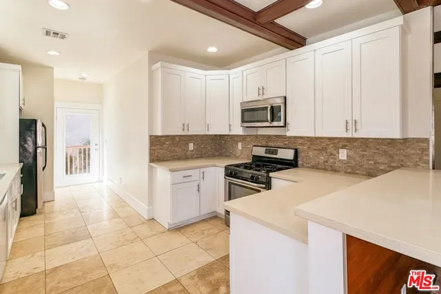 a large kitchen with granite countertop a sink and cabinets